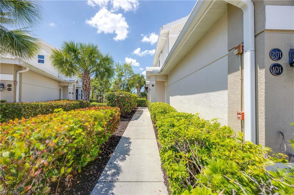 4685 Hawks Nest Way, Unit J201 Naples, FL 34114 - Photo 2 of 24 a front view of a house with a yard and potted plants