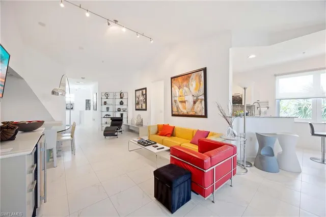 a living room with furniture a rug and white walls