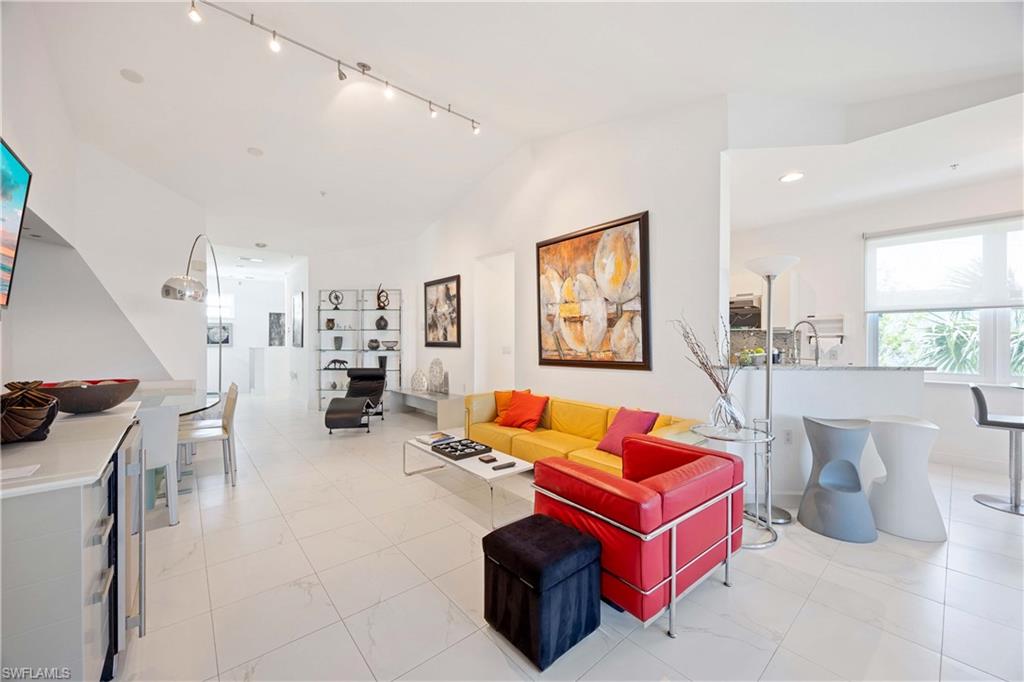 4685 Hawks Nest Way, Unit J201 Naples, FL 34114 - Photo 8 of 24 a living room with furniture a rug and white walls