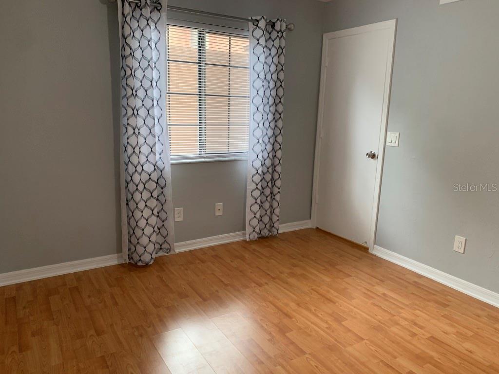 5754 Southwest 8th Place Gainesville, FL 32607 - Photo 21 of 29 an empty room with wooden floor and windows