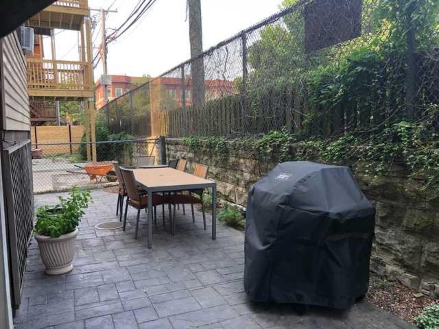 742 West Bittersweet Place, Unit 2W Chicago, IL 60613 - Photo 19 of 21 a backyard of a house with a swing table and chairs