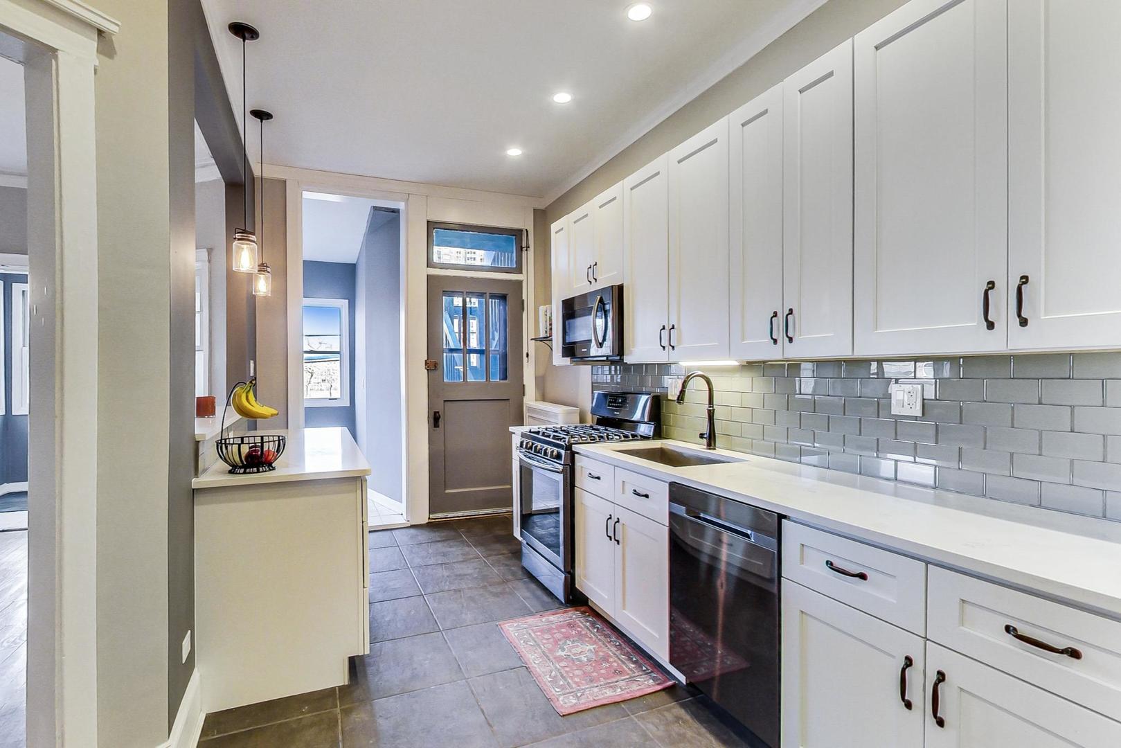 742 West Bittersweet Place, Unit 2W Chicago, IL 60613 - Photo 6 of 21 a kitchen with a sink stove and cabinets