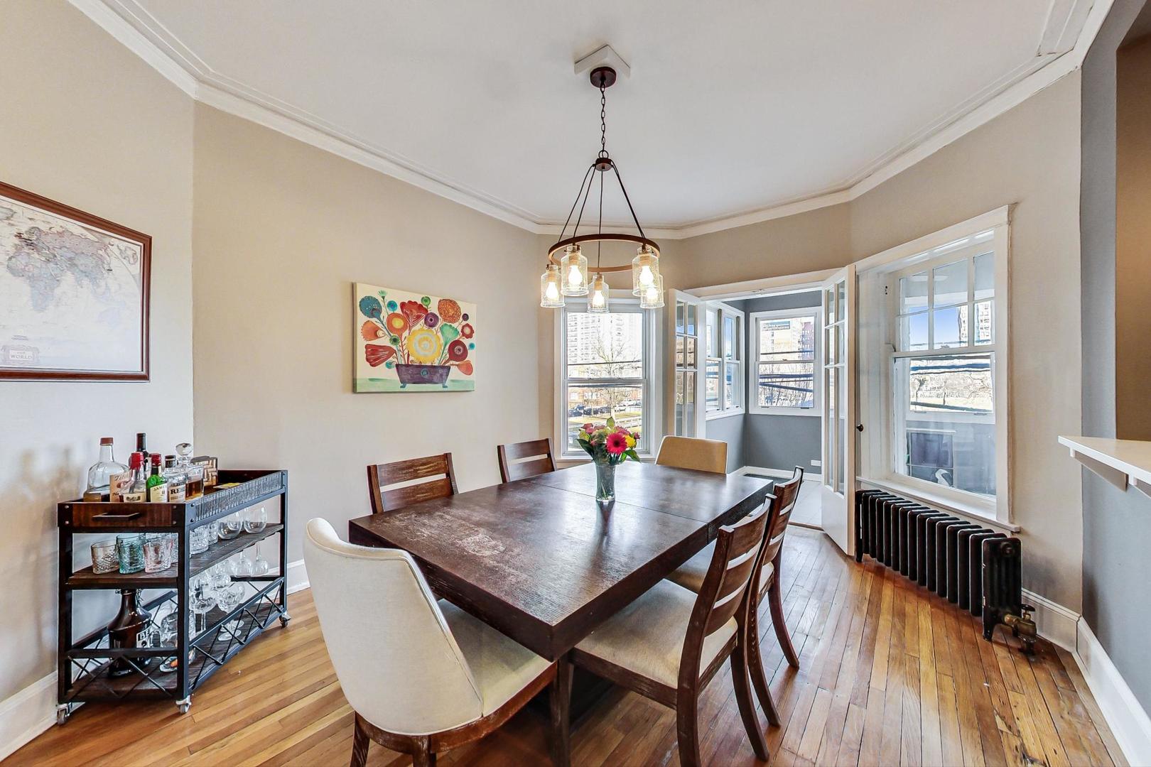 742 West Bittersweet Place, Unit 2W Chicago, IL 60613 - Photo 8 of 21 a dining room with furniture a chandelier and wooden floor