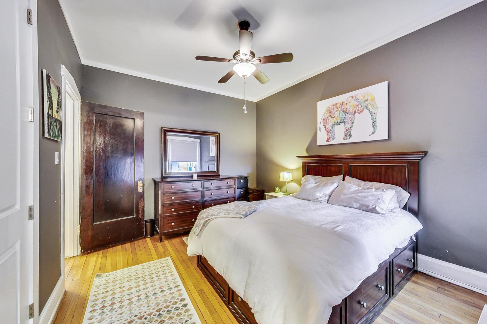 742 West Bittersweet Place, Unit 2W Chicago, IL 60613 - Photo 10 of 21 a bedroom with a large bed and a chandelier