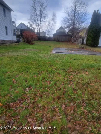 a view of a yard with a house in the background