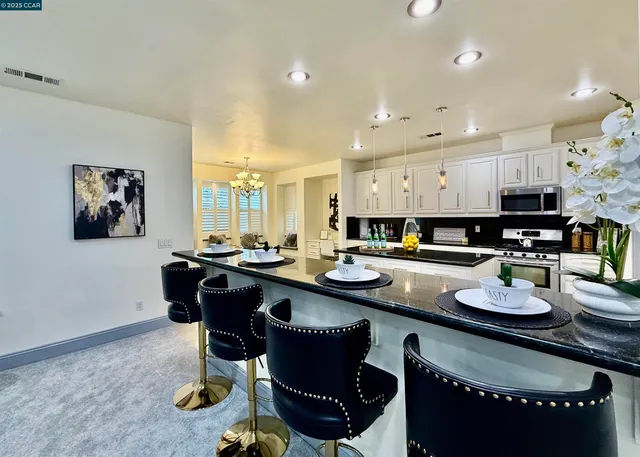 a kitchen with stainless steel appliances granite countertop a sink a stove and a refrigerator