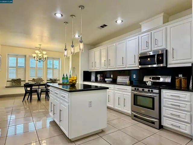 a kitchen with stainless steel appliances granite countertop a stove a sink and a refrigerator