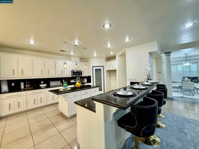 a kitchen with stainless steel appliances kitchen island granite countertop a stove and a sink