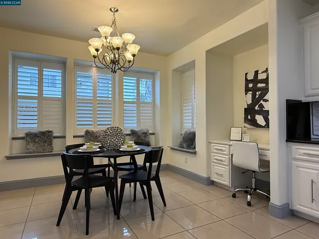 a dining room filled chandelier and kitchen view