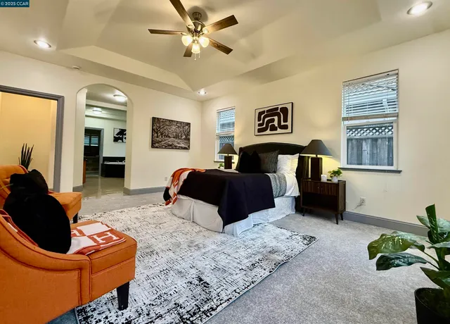 a living room with furniture ceiling fan and a window