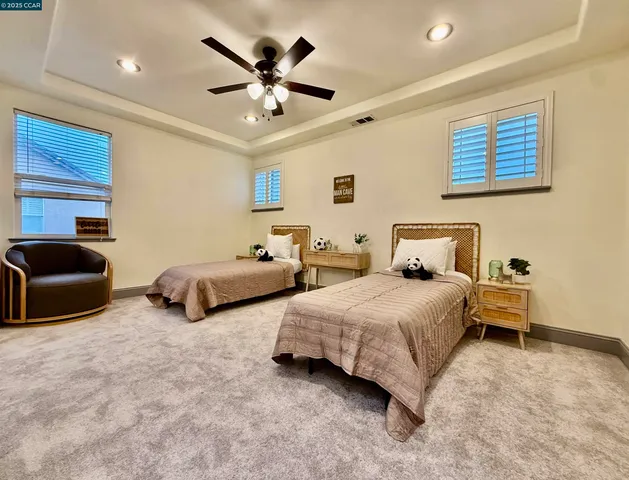 a spacious bedroom with two beds and a chandelier