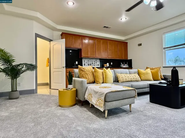 a spacious bedroom with a bed a couch and a potted plant