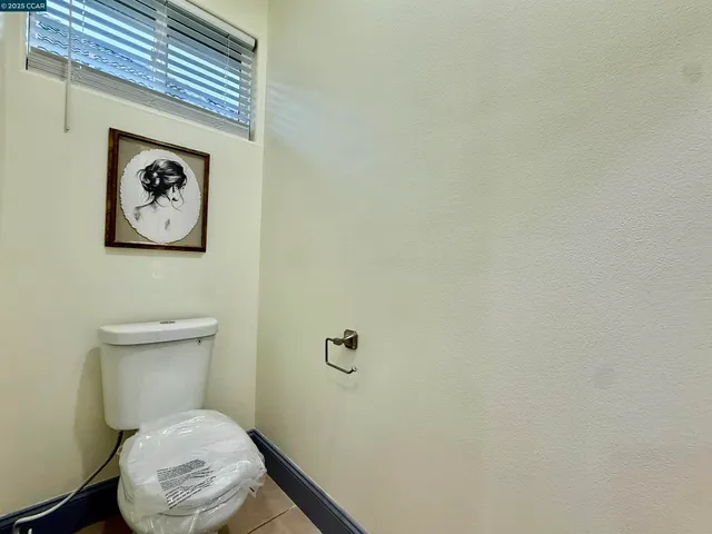 a bathroom with a toilet and a picture on the wall