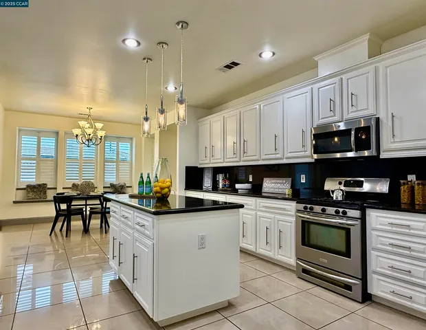 a kitchen with white cabinets and appliances