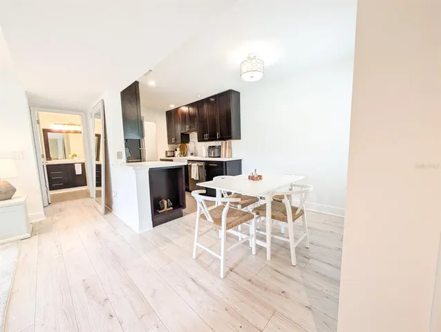 a kitchen with stainless steel appliances kitchen island granite countertop a refrigerator a sink dishwasher and wooden cabinets with a large window