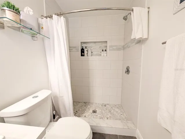 a view of a tennis ground and large trees