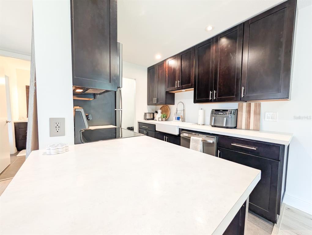 10200 Belle Rive Boulevard, Unit 241 Jacksonville, FL 32256 - Photo 8 of 25 a kitchen with stainless steel appliances kitchen island granite countertop a refrigerator a sink dishwasher and wooden cabinets with a large window