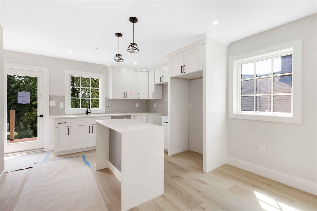 8 Crystal Street, Unit 3 Melrose, MA 02176 - Photo 6 of 24 a view of a kitchen with a sink dishwasher a refrigerator and cabinets