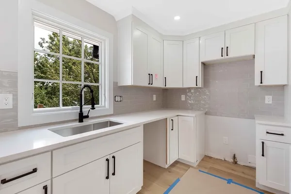 a kitchen with stainless steel appliances white cabinets and a sink