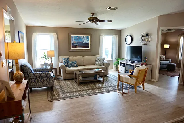 a living room with furniture flat screen tv and wooden floor