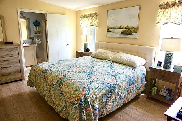 a bedroom with a bed and wooden floor
