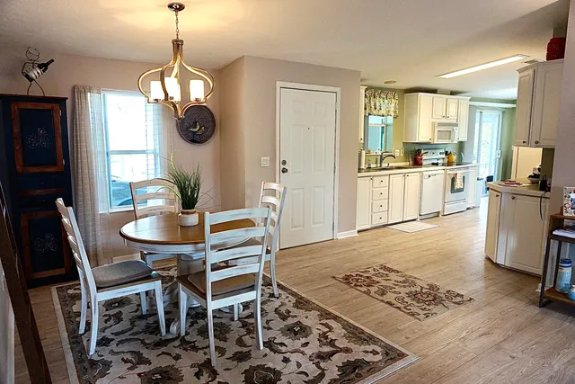 a view of a dining room with furniture a chandelier and wooden floor