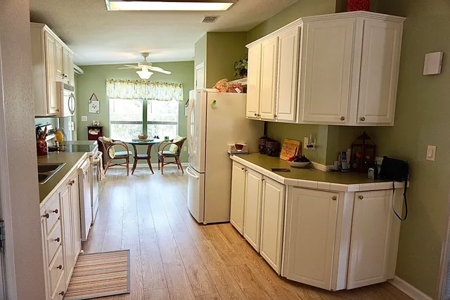 a kitchen with cabinets and wooden floor