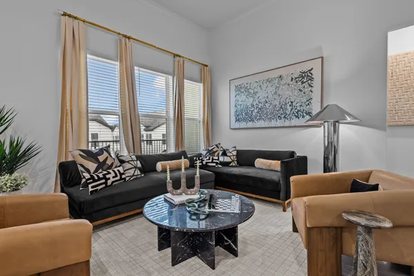 a living room with furniture and a large window with rug