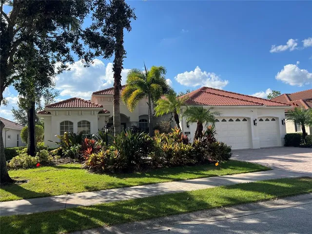 a front view of a house with a yard and a fountain