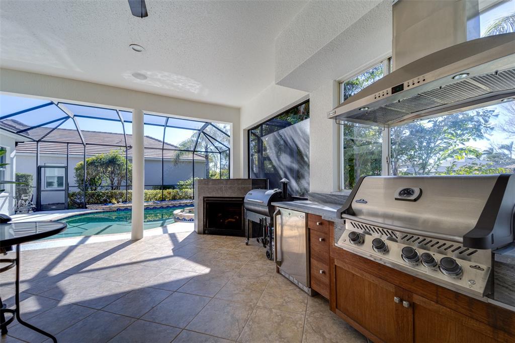 14721 Bowfin Terrace Lakewood Ranch, FL 34202 - Photo 11 of 50 a open kitchen with a stove a flat screen tv and a large window