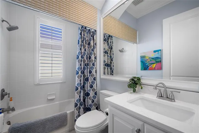 a bathroom with a sink a toilet a window and shower