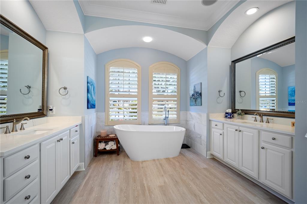 14721 Bowfin Terrace Lakewood Ranch, FL 34202 - Photo 24 of 50 a spacious bathroom with double vanity a mirror a bathtub and window