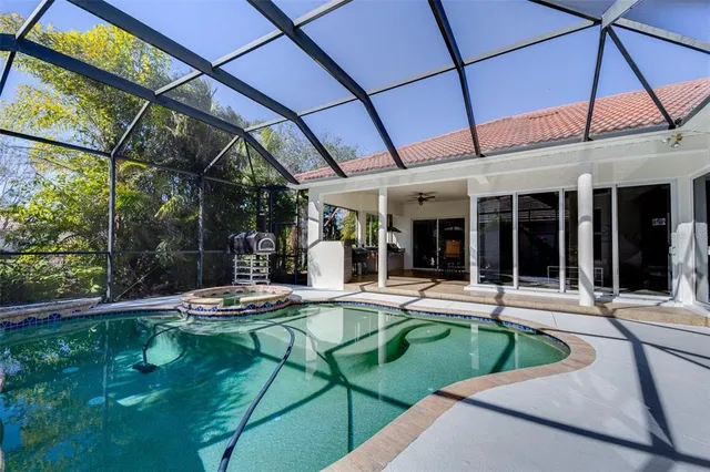 a view of house with swimming pool and outdoor seating