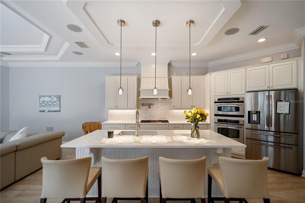 14721 Bowfin Terrace Lakewood Ranch, FL 34202 - Photo 9 of 50 a kitchen with stainless steel appliances a dining table chairs sink and microwave