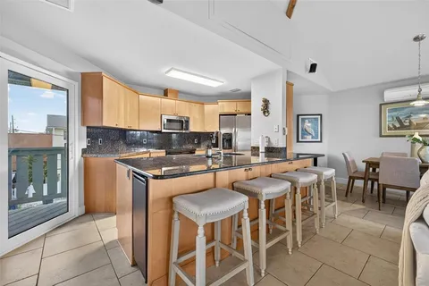 a kitchen with stainless steel appliances granite countertop a table and chairs