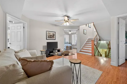 a living room with furniture and a wooden floor