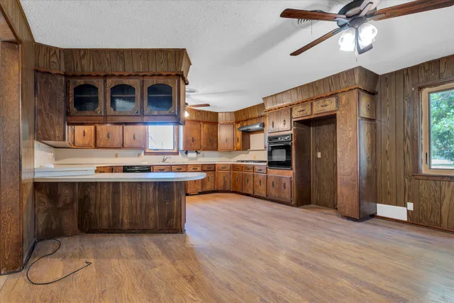 a kitchen with stainless steel appliances granite countertop a refrigerator a stove and a wooden floors