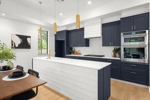 a kitchen with a sink a stove and cabinets