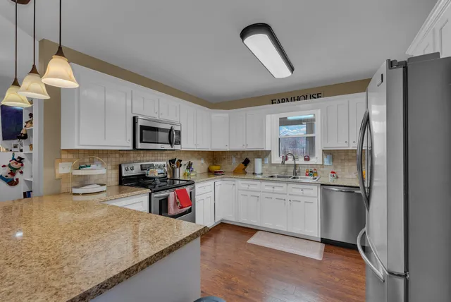 a kitchen with stainless steel appliances granite countertop a refrigerator sink and stove