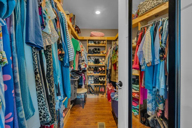 a view of walk in closet with clothes and shoes