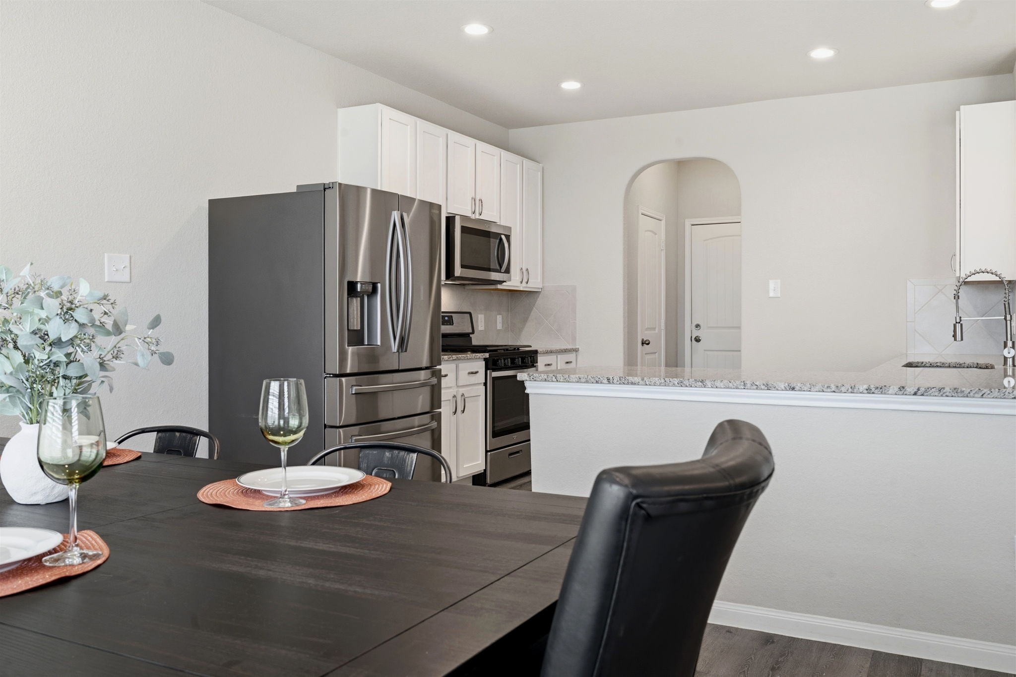 2542 Sturgeon Way Conroe, TX 77384 - Photo 11 of 40 a kitchen with stainless steel appliances granite countertop a dining table and chairs