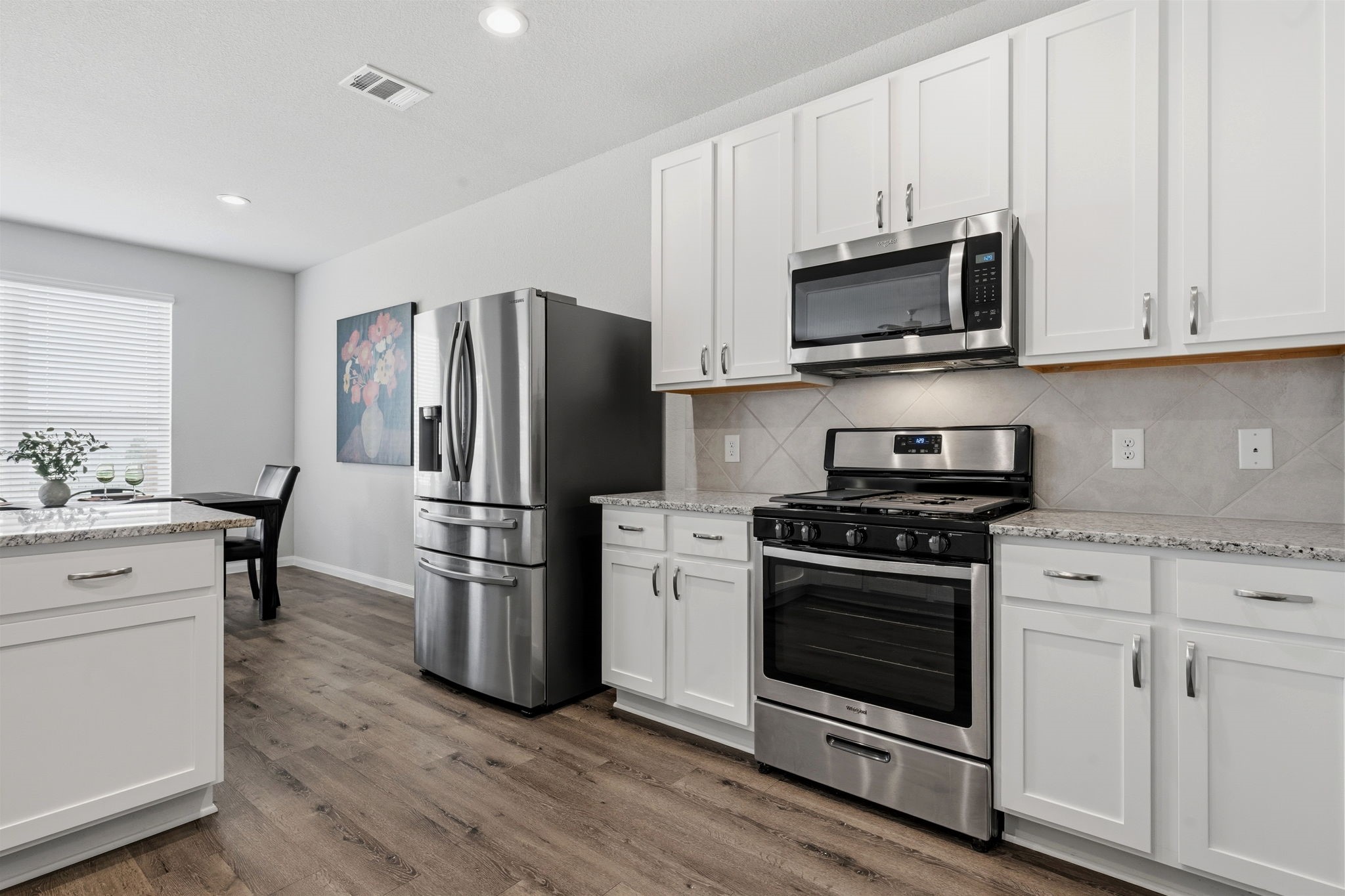 2542 Sturgeon Way Conroe, TX 77384 - Photo 12 of 40 a kitchen with cabinets stainless steel appliances and wooden floor