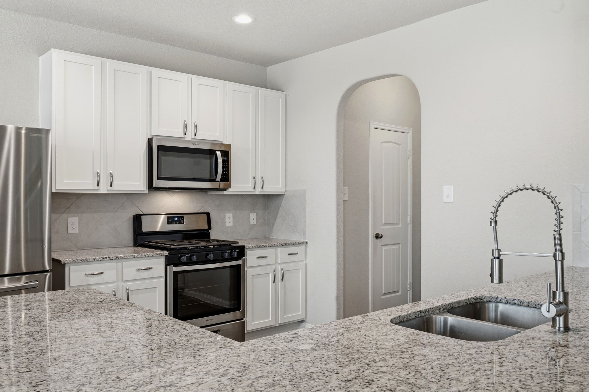 2542 Sturgeon Way Conroe, TX 77384 - Photo 14 of 40 a kitchen with stainless steel appliances granite countertop a sink a stove and cabinets