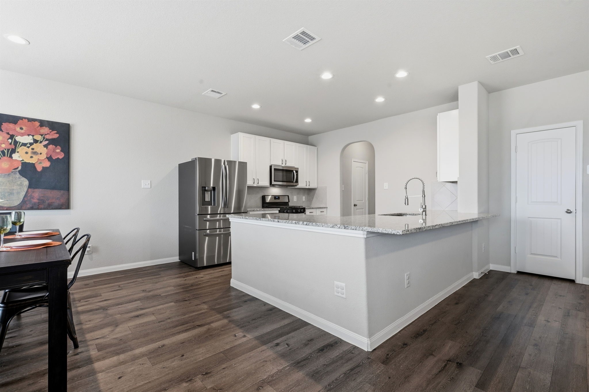 2542 Sturgeon Way Conroe, TX 77384 - Photo 15 of 40 a view of kitchen with refrigerator microwave and wooden floor