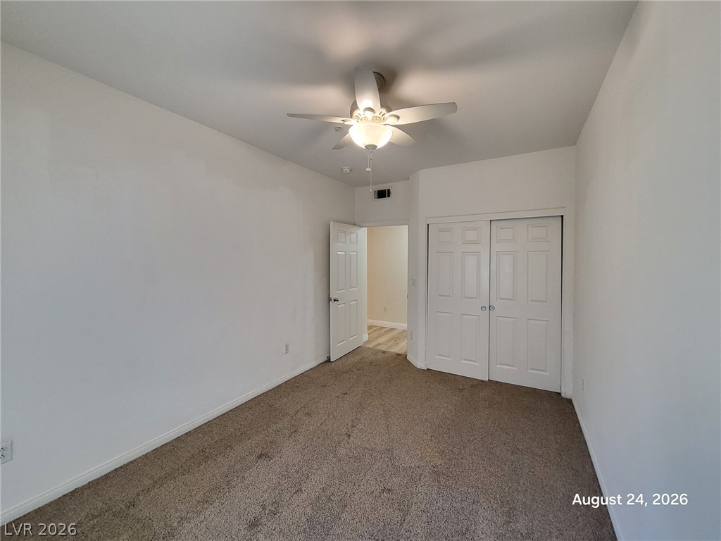7701 West Robindale Road, Unit 125 Las Vegas, NV 89113 - Photo 10 of 16 Smooth plaster walls and neutral carpeting anchor this versatile secondary bedroom space.