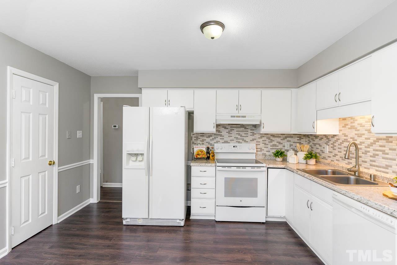 4209 Traders Dock Court Raleigh, NC 27616 - Photo 4 of 17 a kitchen with a refrigerator a sink and dishwasher with wooden floors