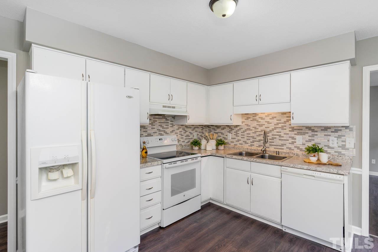 4209 Traders Dock Court Raleigh, NC 27616 - Photo 5 of 17 a kitchen with white cabinets and white appliances