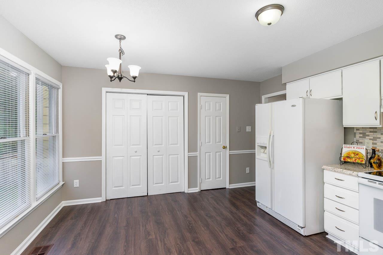 4209 Traders Dock Court Raleigh, NC 27616 - Photo 7 of 17 a view of a kitchen with a refrigerator and wooden floor cabinets
