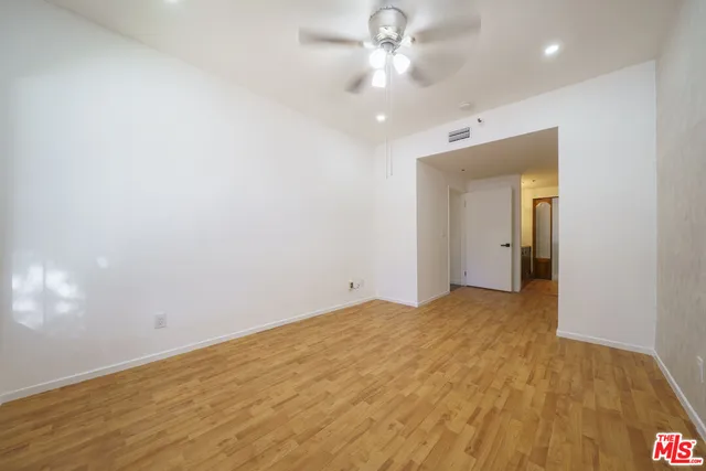 an empty room with a bathroom and a ceiling fan