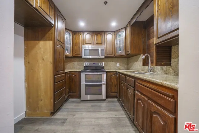 a kitchen with stainless steel appliances granite countertop a refrigerator stove and sink